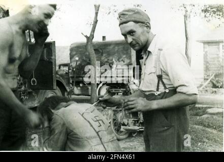 WWII - OPERAZIONE BARBAROSSA - SOLDATI TEDESCHI CHE SCRIVONO SWASTIKA PRIGIONIERO SOVIETICO DI GUERRA Foto Stock