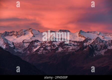 L'alba rossa sul massiccio innevato delle Maladetas e la vetta dell'Aneto. Vista dalla valle di Varradòs in autunno (Valle di Aran, Catalogna, Spagna) Foto Stock