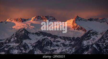 Alba rossa sul massiccio innevato delle Maladetas visto dalla Valle di Varradòs in autunno (Valle di Aran, Catalogna, Spagna) Foto Stock