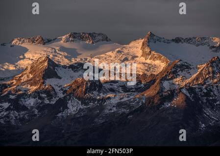 Alba rossa sul massiccio innevato delle Maladetas visto dalla Valle di Varradòs in autunno (Valle di Aran, Catalogna, Spagna) Foto Stock