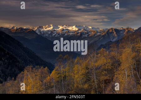 L'alba rossa sul massiccio innevato delle Maladetas e la vetta dell'Aneto. Vista dalla valle di Varradòs in autunno (Valle di Aran, Catalogna, Spagna) Foto Stock