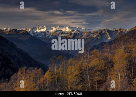 Alba rossastra sul massiccio innevato delle Maladetas e sulla vetta di Aneto. Vista dalla valle di Varradòs in autunno (Valle di Aran, Catalogna, Spagna) Foto Stock