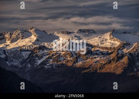 L'alba rossa sul massiccio innevato delle Maladetas e la vetta dell'Aneto. Vista dalla valle di Varradòs in autunno (Valle di Aran, Catalogna, Spagna) Foto Stock