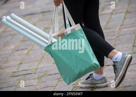 Stralsund, Germania. 14 maggio 2021. Una persona porta una borsa per lo shopping sulla strada dello shopping e zona pedonale Ossenreyer Street sono numerosi passanti, maschere sono obbligatorie. Retail nel distretto di Vorpommern-Rügen riapre, è il primo distretto di Meclemburgo-Pomerania occidentale, in cui i negozi sono autorizzati ad aprire completamente di nuovo, perché l'incidenza di sette giorni vi è già al di sotto di 50. Credit: Stefan Sauer/dpa/Alamy Live News Foto Stock