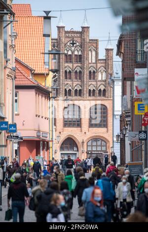 Stralsund, Germania. 14 maggio 2021. Sulla strada dello shopping e zona pedonale Ossenreyer Street sono numerosi passanti, maschere sono obbligatori. Retail nel distretto di Vorpommern-Rügen riapre, è il primo distretto di Meclemburgo-Pomerania occidentale dove i negozi sono autorizzati a riaprire completamente, perché l'incidenza di sette giorni vi è già al di sotto di 50. Credit: Stefan Sauer/dpa/Alamy Live News Foto Stock