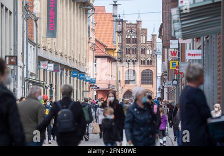 Stralsund, Germania. 14 maggio 2021. Sulla strada dello shopping e zona pedonale Ossenreyer Street sono numerosi passanti, maschere sono obbligatori. Retail nel distretto di Vorpommern-Rügen riapre, è il primo distretto di Meclemburgo-Pomerania occidentale dove i negozi sono autorizzati a riaprire completamente, perché l'incidenza di sette giorni vi è già al di sotto di 50. Credit: Stefan Sauer/dpa/Alamy Live News Foto Stock