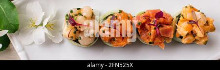 Rainbow Sushi Roll con salmone, tonno, avocado, gamberi reali, crema di formaggio Filadelfia, caviale tobica, chuka. Menu sushi. Cibo giapponese Foto Stock
