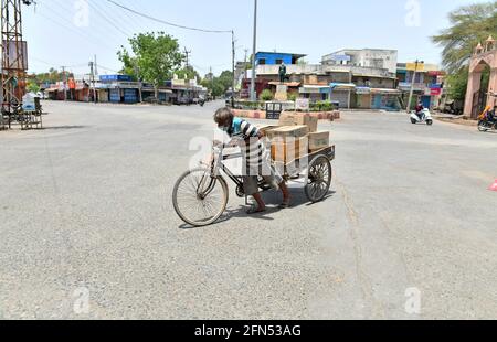 Beawar, Rajasthan, India, 13,2021 maggio: Il lavoratore indiano spinge un carrello a tre cicli carico di beni di consumo in un mercato desertato durante il blocco COVID-19 in corso a Beawar. Credit: Sumit Saraswat/Alamy Live News Foto Stock