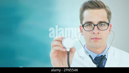 Ritratto del medico maschio caucasico che tiene stetoscopio contro il gradiente verde sfondo Foto Stock
