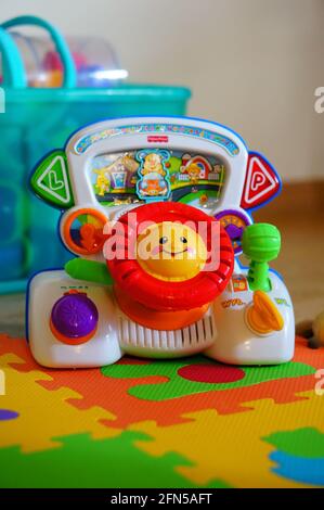 POZNAN, POLONIA - 04 gennaio 2015: Cruscotto giocattolo colorato Fisher Price con volante, interruttori e pulsanti sul pavimento. Foto Stock