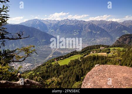 Vista panoramica ad alto angolo sulla città di Merano e la catena montuosa di Texelgruppe vista dall'iconico punto panoramico 'Knottnkino' a Vöran, Alto Adige, Italia Foto Stock
