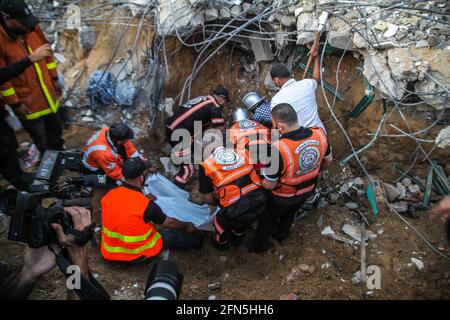 Gaza, Palestina. 13 maggio 2021. Le squadre palestinesi di difesa civile hanno partecipato ai lavori di salvataggio per recuperare un corpo dalle macerie di un edificio appartenente ad una famiglia palestinese dopo che i jet israeliani da combattimento hanno lanciato attacchi aerei che hanno distrutto un intero quartiere residenziale a Beit Lahiya, Gaza, il 13 maggio 2021. (Foto di Ramez Habboub/Pacific Press/Sipa USA) Credit: Sipa USA/Alamy Live News Foto Stock