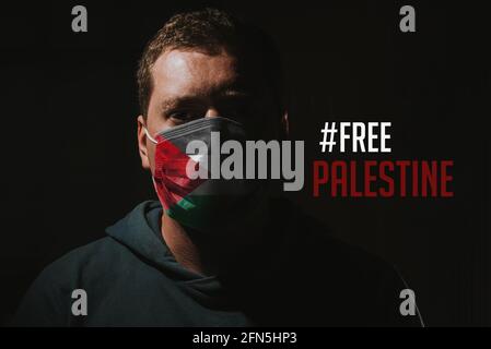 uomo con maschera facciale e bandiera palestinese con testo libero palestina Foto Stock