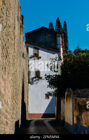 Strette strade acciottolate e case dipinte tradizionalmente ad Obidos, Portogallo. Foto Stock