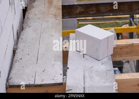 Costruzione di un blocco di cemento aerato in un cantiere Foto Stock