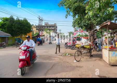 Cuttack, Odisha, India - 24 luglio 2019 : Banana e altri ortaggi sono in vendita a bordo strada. Un uomo sta passando dal mercato nel suo scooter, in un mar Foto Stock