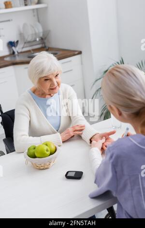 vista ad angolo alto dell'infermiere che effettua l'iniezione di insulina a un anziano donna diabetica Foto Stock