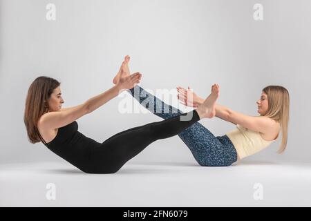 due ragazze che fanno cento pilates postura Foto Stock