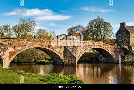 Il vecchio ponte Nungate, con arcate, si riflette nelle acque del fiume Tyne in una giornata di sole, Haddington, East Lothian, Scozia, Regno Unito Foto Stock