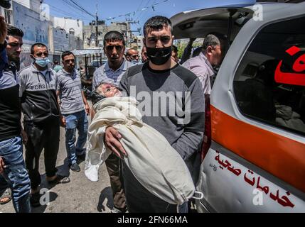 Gaza, Palestina. 14 maggio 2021. (NOTA DELLA REDAZIONE: Immagine della morte) il palestinese porta il corpo di un bambino, Ibrahim al-Rantisi, ucciso durante un attacco aereo israeliano, prima della sua sepoltura a Rafah, nella striscia di Gaza meridionale. Credit: SOPA Images Limited/Alamy Live News Foto Stock