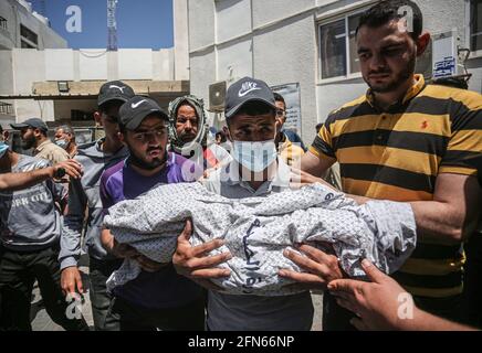 Gaza, Palestina. 14 maggio 2021. (NOTA DELLA REDAZIONE: Immagine della morte) il palestinese porta il corpo di un bambino, Ibrahim al-Rantisi, ucciso durante un attacco aereo israeliano, prima della sua sepoltura a Rafah, nella striscia di Gaza meridionale. Credit: SOPA Images Limited/Alamy Live News Foto Stock