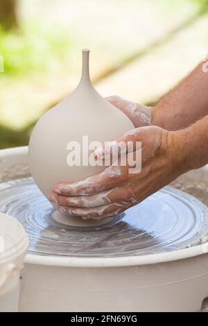 Potters mani abilmente mano gettando una ceramica gettato vaso di argilla su una ruota di rotazione. Inghilterra. UK (123) Foto Stock