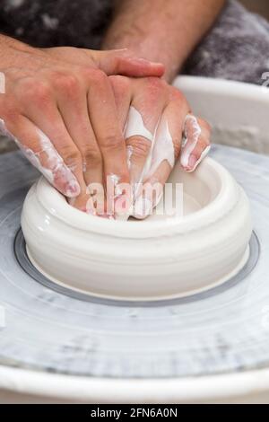 Potters mani abilmente mano gettando una ceramica gettato vaso di argilla su una ruota di rotazione. Inghilterra. UK (123) Foto Stock