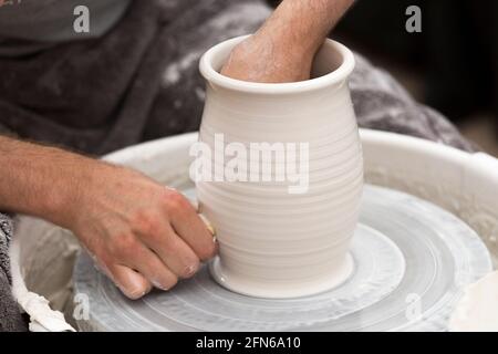 Potter / vasai mani abilmente mano gettando una ceramica gettato vaso di argilla su una ruota di rotazione. Inghilterra. UK (123) Foto Stock