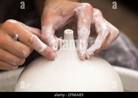 Potter / vasai mani abilmente mano gettando una ceramica gettato vaso di argilla su una ruota di rotazione. Inghilterra. UK (123) Foto Stock