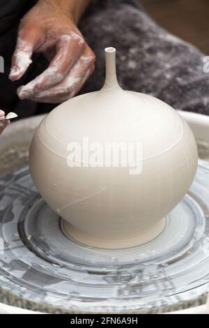 Potter / vasai mani abilmente mano gettando una ceramica gettato vaso di argilla su una ruota di rotazione. Inghilterra. UK (123) Foto Stock