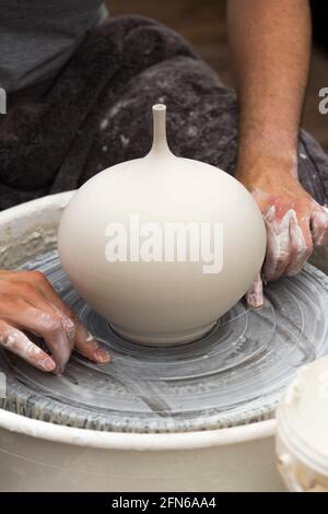 Potters mani abilmente mano gettando una ceramica gettato vaso di argilla su una ruota di rotazione. Inghilterra. UK (123) Foto Stock