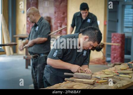 Gli studenti dell'istituto di arte e artigianato di te Puia sono addestrati alla tradizionale scultura Maori. Foto Stock