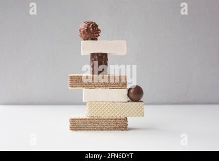 Stack di snack dolci sul tavolo bianco. Concetto di equilibrio. Foto Stock