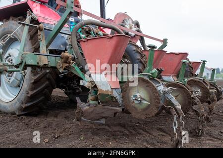Primo piano dei contenitori per la semina sulle attrezzature del trattore sul campo in primavera Foto Stock
