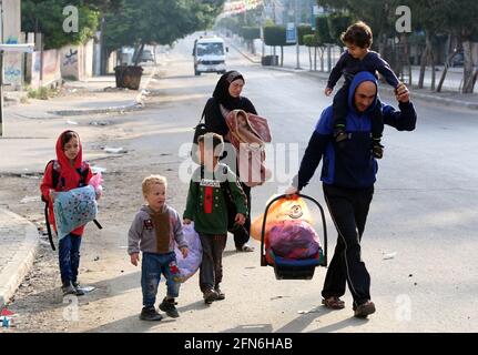 Gaza, Palestina. 14 maggio 2021. I palestinesi fuggono dalle loro case nel quartiere di Shejaiya durante un attacco aereo israeliano sulla città di Gaza in mezzo all'escalation della violenza israelo-palestinese. (Foto di Ahmed Zakot/SOPA Images/Sipa USA) Credit: Sipa USA/Alamy Live News Foto Stock