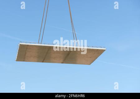 La lastra di pavimento prefabbricata vola attraverso l'aria di fronte bue cielo Foto Stock