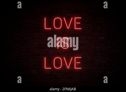 Illuminato e luminoso 'L'AMORE È L'AMORE' segno rosso al neon su pareti di mattoni scuri. Foto Stock