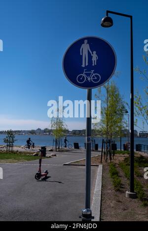 Helsinki / Finlandia - 14 MAGGIO 2021: Primo piano di un cartello stradale che indica un passaggio pedonale combinato e una corsia per biciclette. Foto Stock