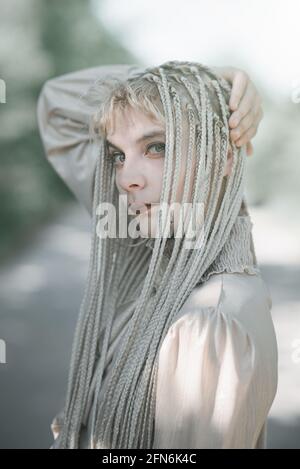 Giovane donna elegante che posa per ritratti all'esterno, bellezza e concetto di moda Foto Stock