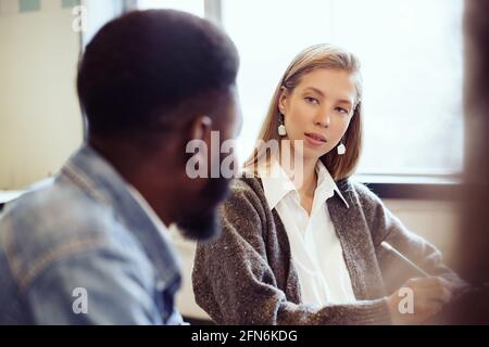 Donna d'affari che ascolta il cliente africano americano maschio che sta parlando Foto Stock