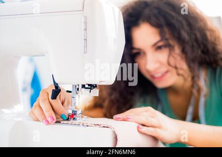Vista ravvicinata delle mani femminili da cucire Foto Stock