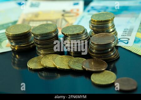 Crisi finanziaria sistemica. Banconote e monete con riflessione su vetro nero. Foto Stock