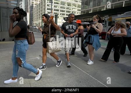 New York City, Stati Uniti. 14 maggio 2021. La gente cammina lungo la 42nd Street e la 6th Avenue senza maschere, dopo che il CDC ha aggiornato le sue linee guida COVID-19, annunciando che le persone completamente vaccinate possono rinunciare a indossare maschere per il viso all'aperto e al chiuso o a distanza sociale, New York, NY, 15 maggio 2021. Il CDC ha inoltre raccomandato che le persone completamente vaccinate continuino a indossare maschere durante i viaggi o nelle aree affollate; le persone sono considerate completamente vaccinate contro COVID-19 due settimane dopo l'ultimo vaccino vaccinato. (Foto di Anthony Behar/Sipa USA) Credit: Sipa USA/Alamy Live News Foto Stock