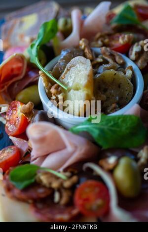 tabella piena di prodotti mediterranei quali frutta a guscio, prosciutto, formaggio, olive, pomodoro, melanzane., olive, pomodoro, melanzane., olive, pomodoro, melanzane. Foto Stock