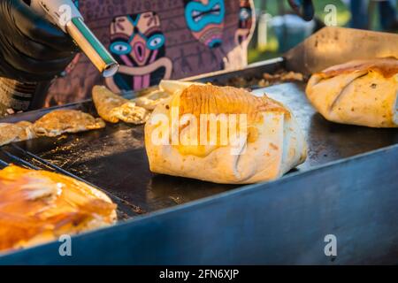 Kazan, Russia - 03 ottobre 2020: Uno chef di un ristorante messicano di strada fonde il formaggio su un hamburger avvolto da tortilla con un bruciatore a gas portatile. Foto Stock