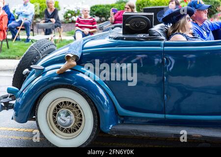 Una coppia passa attraverso Auburn, Indiana, nel loro antico roadster Auburn con qualcuno intrappolato nel sedile rumble. Foto Stock