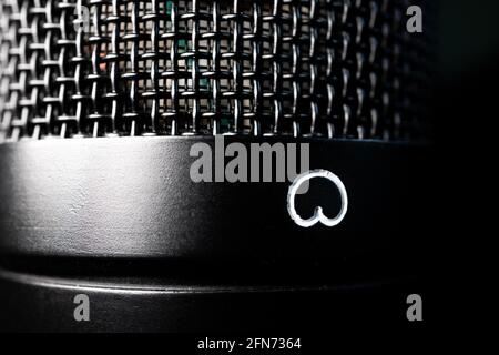 Macro closeup del corpo del microfono del condensatore a diaframma grande isolato, della griglia e del simbolo del pattern cardioide Foto Stock