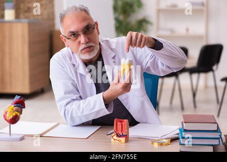 Vecchio insegnante di dentista seduto in classe Foto Stock