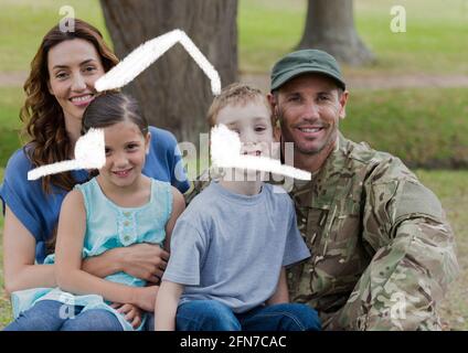 Composizione di disegno di casa su ritratto di soldato maschile con sua moglie e i suoi figli Foto Stock