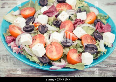 Insalata greca fresca con formaggio feta e verdure come pasto sano contenente vitamine e minerali naturali Foto Stock